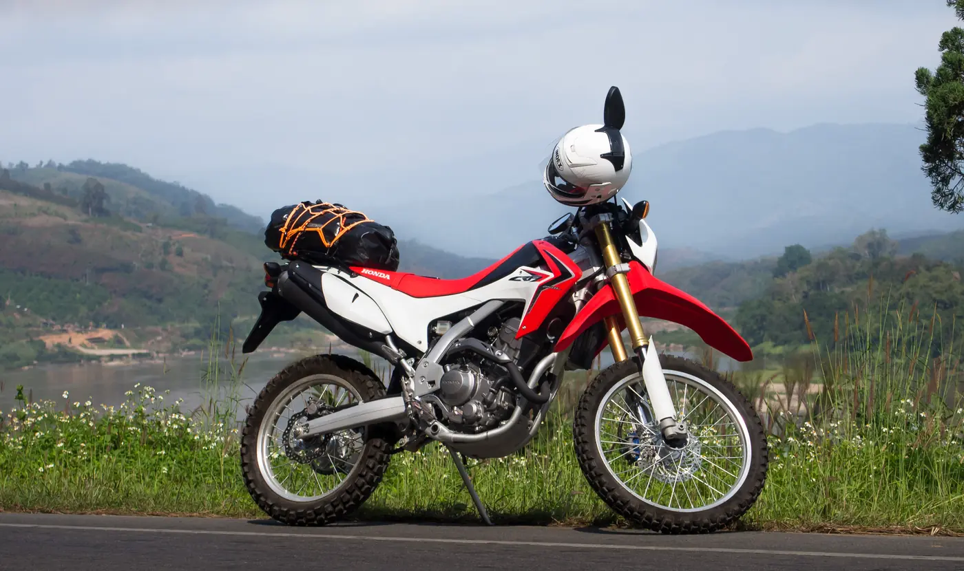 small trail motorcycle parked on a green lane